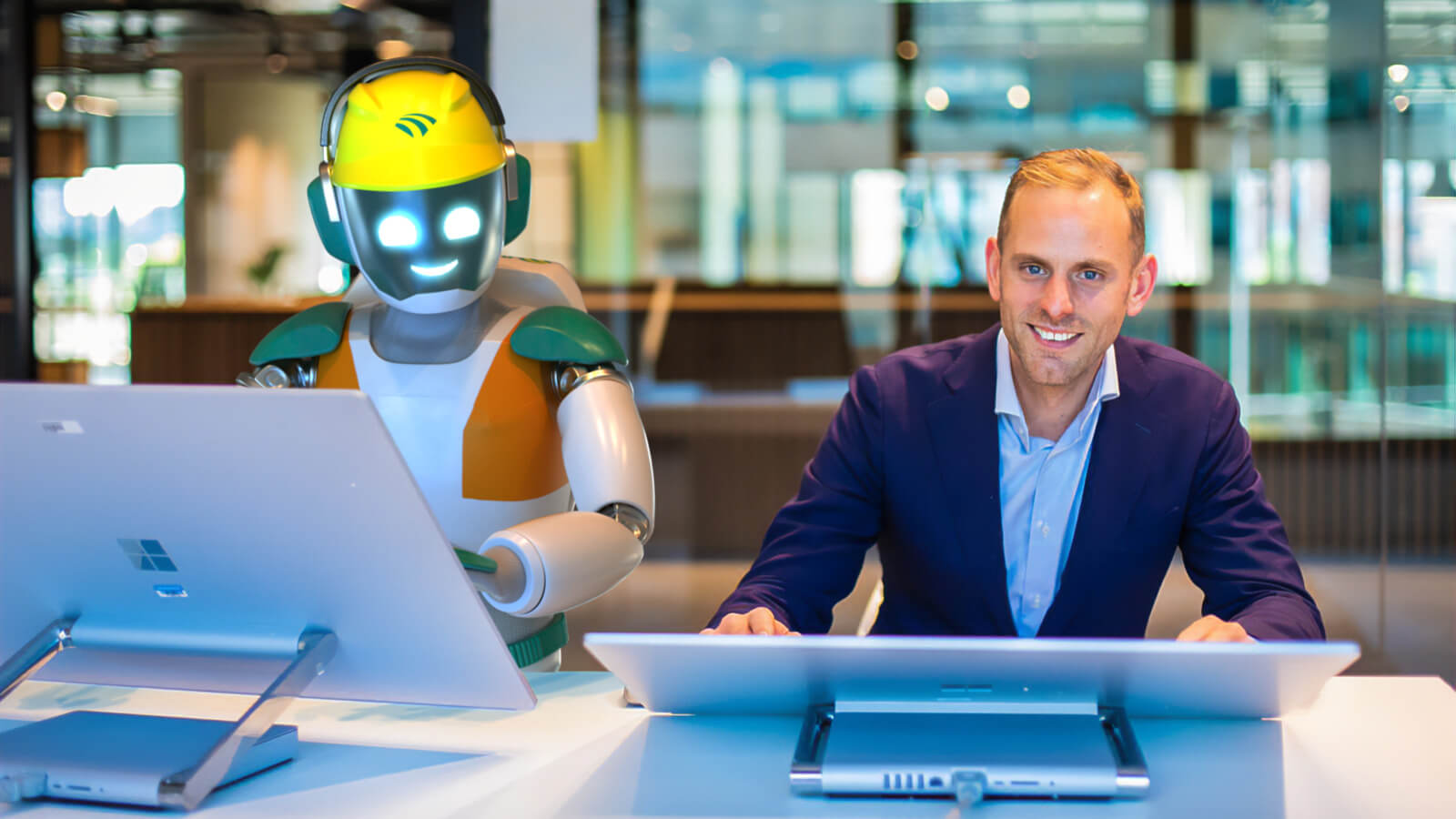 Lou de Bouwer aan het werk achter een touchscreen met een collega bij Dura Vermeer. 