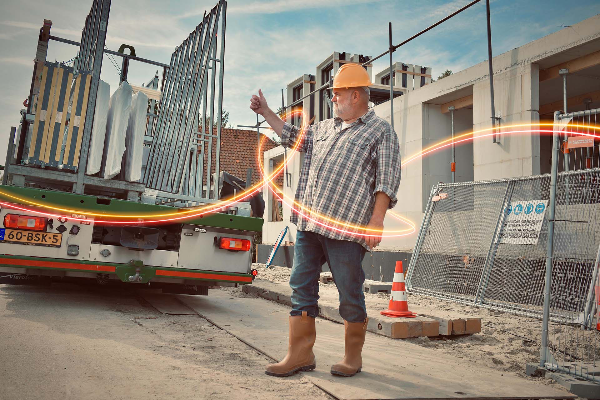 Man met helm op de bouwplaats waar materialen voor de bouw worden geleverd.